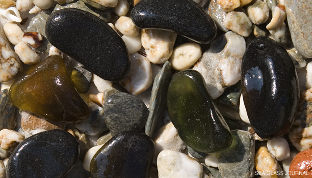 Black sea glass can look like stones on the beach.